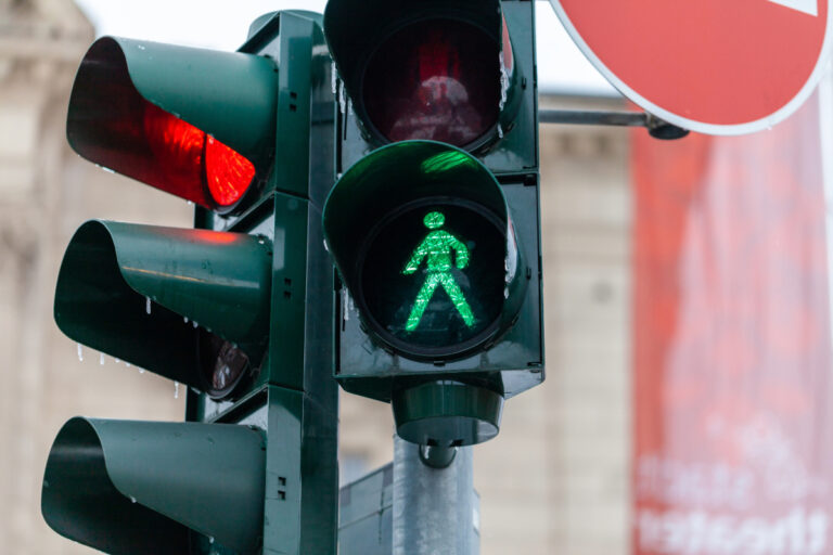 Eine Verkehrsampel zeigt eine rote Ampel und eine grüne Fußgängerampel.